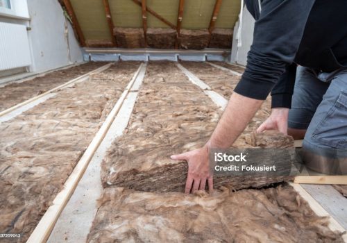 Man insulating the attic with rock wool.