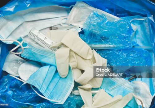 Medical trash. Coronavirus protection equipment in medical waste bin. Used face masks and sterile gloves. Doctor uniform for patient treatment in hospital. Prevention the spread of COVID-19.